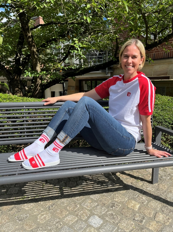 Weibliches Model mit T-Shirt in weiß mit roten mit weißen Strichen Ärmeln, rotes Finanz Informatik Logo auf der linken Brust
